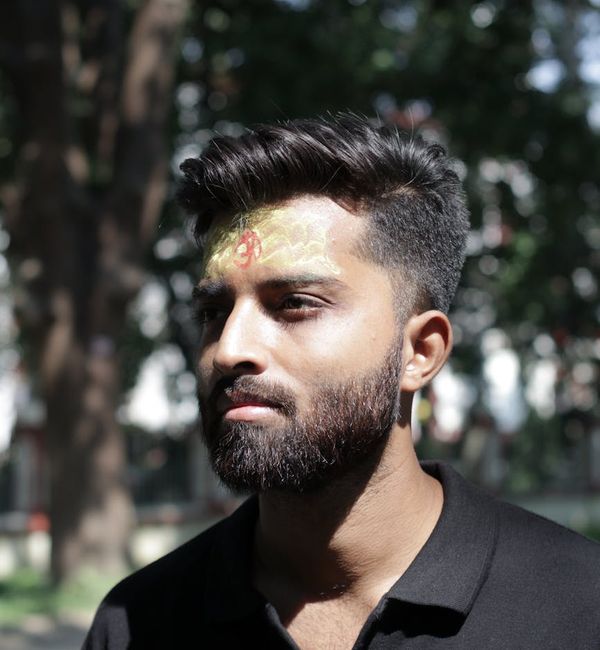 Person meditating outdoors with a calm and focused expression.